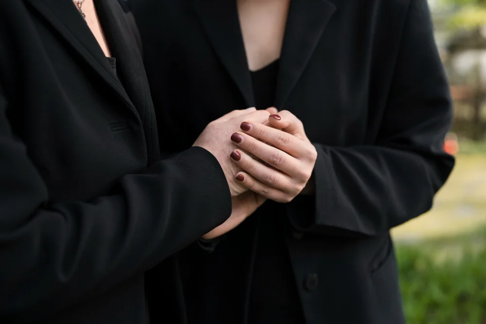 people holding hands at a funeral