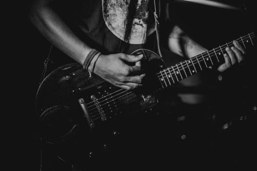 man holding and playing a guitar