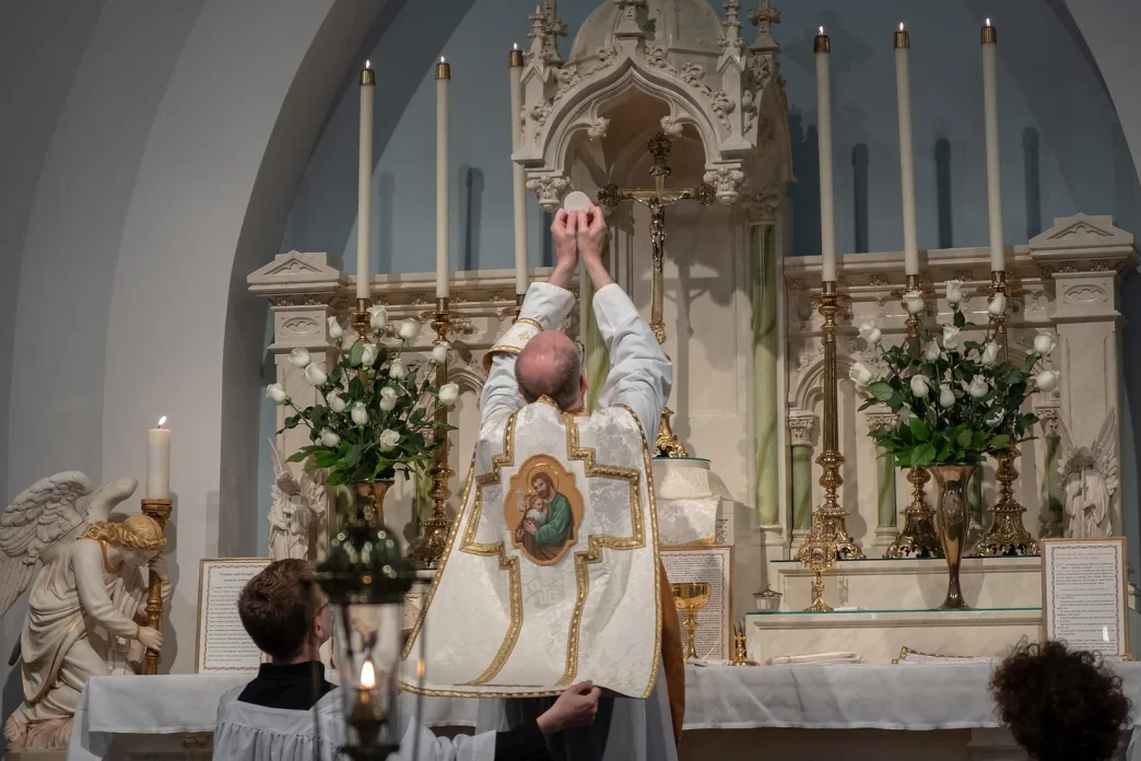 priest at Catholic funeral offering holy communion