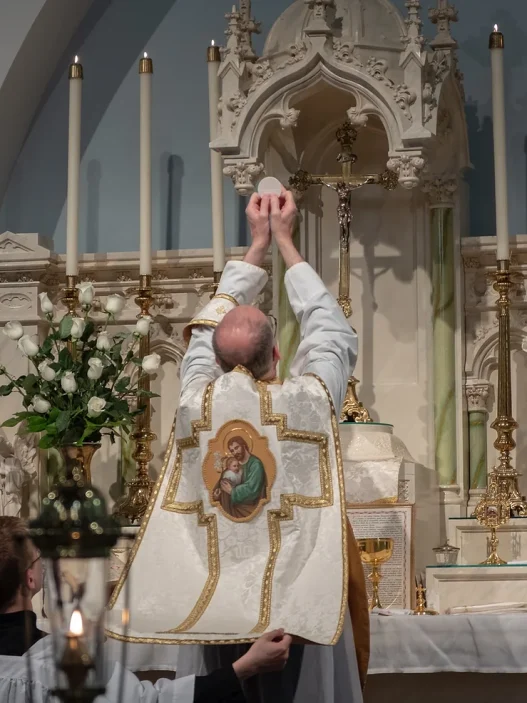 priest at Catholic funeral offering holy communion