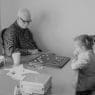 man and little girl playing checkers