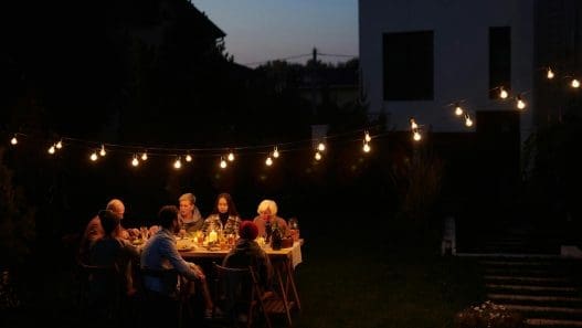 family sitting by table at garden
