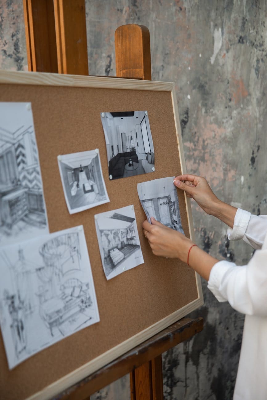 person pinning a paper on a corkboard